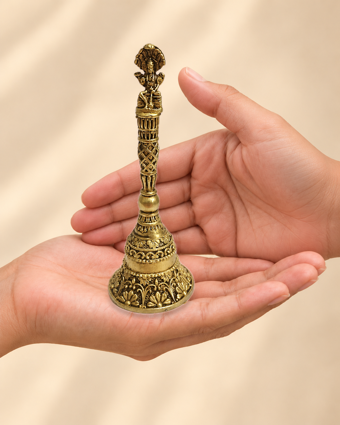 Illustrative scale view of Ganesha Brass Pooja Bell – 5 Inch resting on an adult open palm; listed height 5 inches.