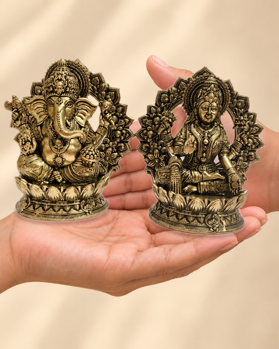 Illustrative scale view of Lakshmi Ganesha Brass Idol Pair With Lotus Backplates resting on an adult open palm; listed height 4 inches.