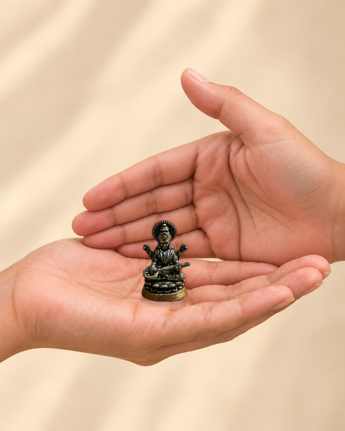 Illustrative scale view of Mini Saraswati Brass Idol With Veena resting on an adult open palm; listed height 1.5 inches.