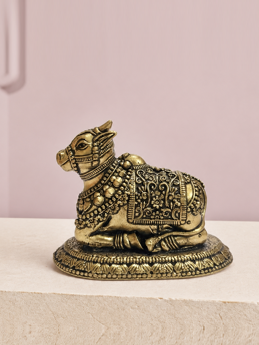 Nandi Brass Idol on an ivory platform with a soft mauve heritage backdrop