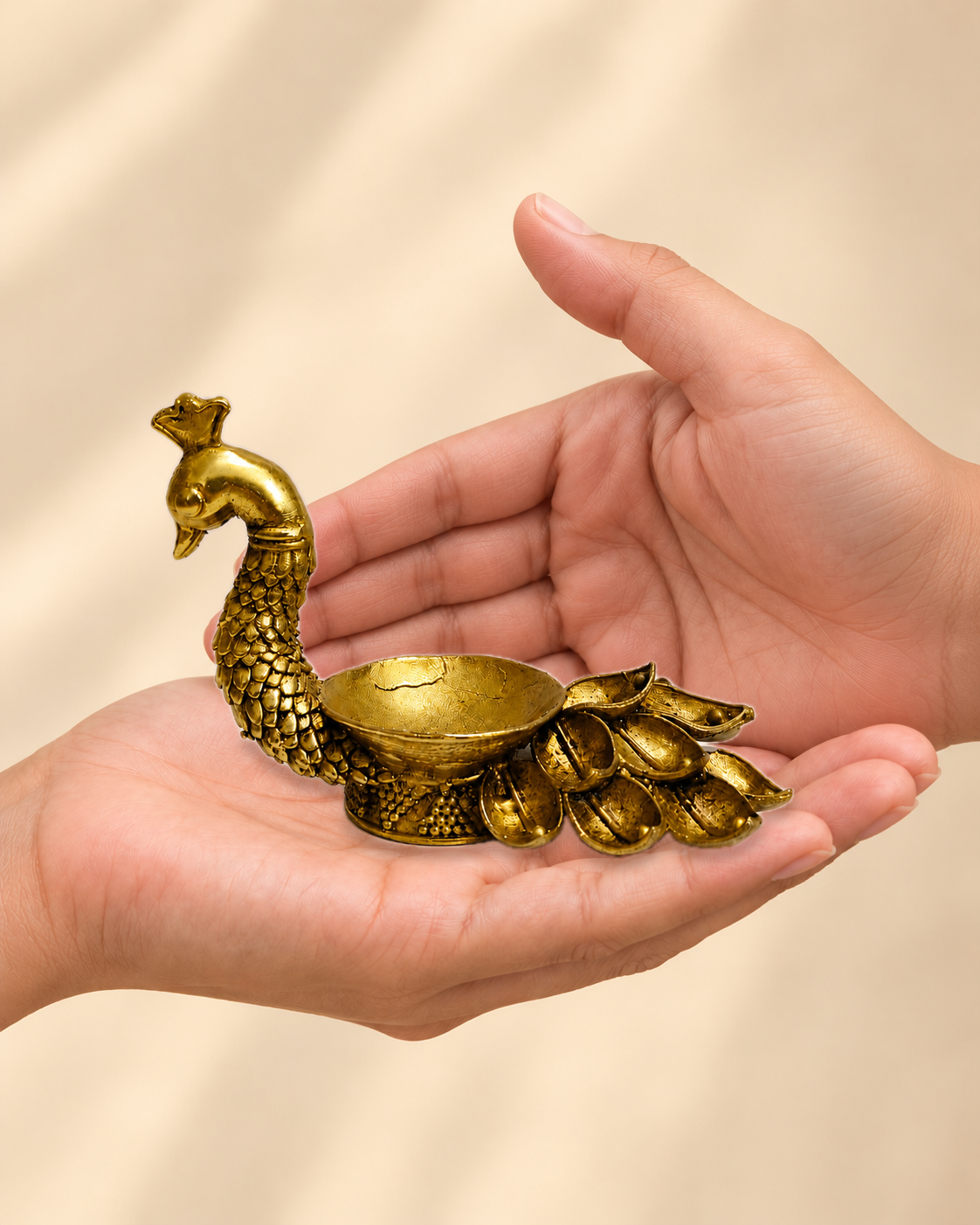 Illustrative scale view of Peacock Lotus Tail Brass Diya resting on an adult open palm; listed height 3 inches.