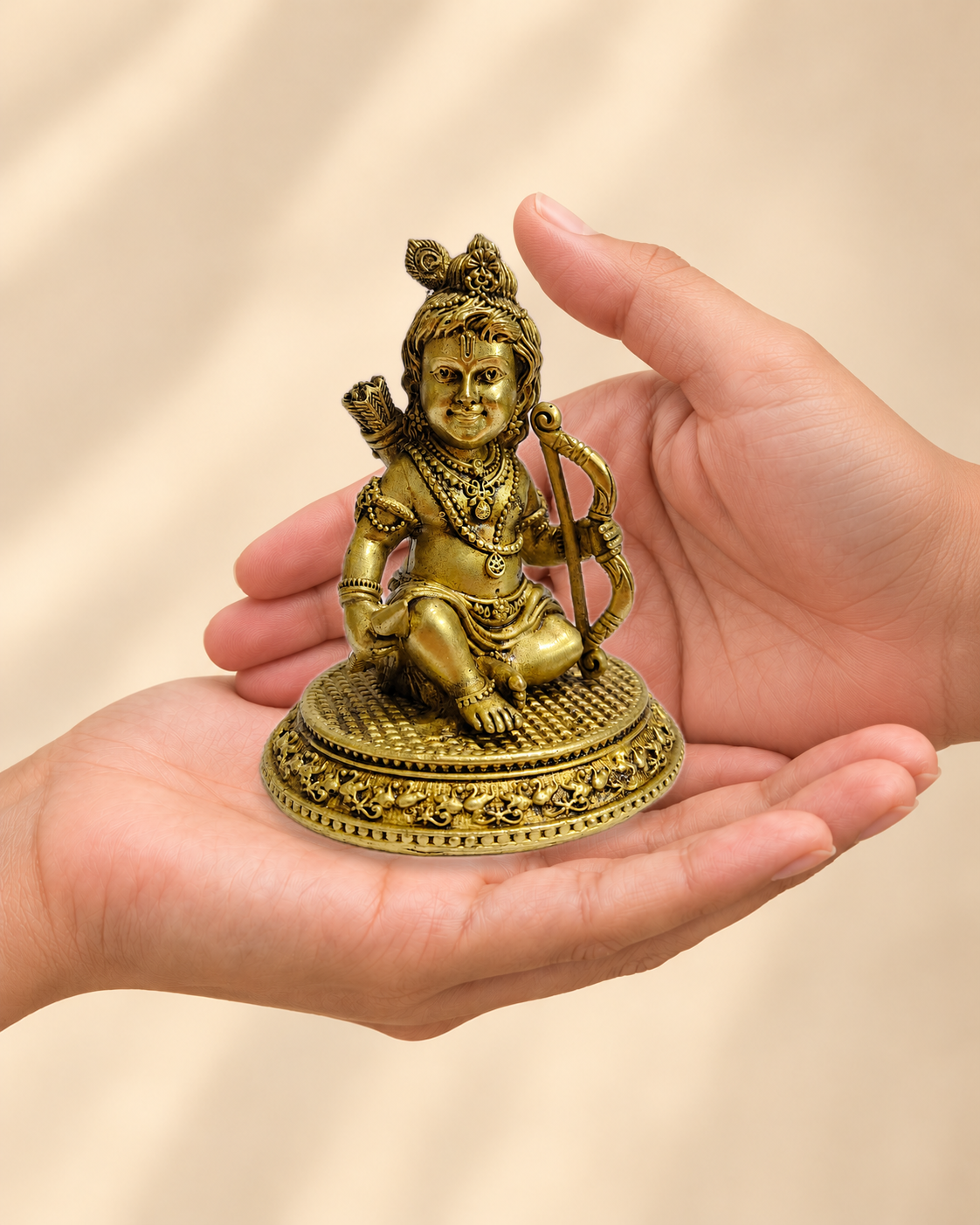 Illustrative scale view of Ram Lalla Brass Idol with Bow and Arrows resting on an adult open palm; listed height 4 inches.