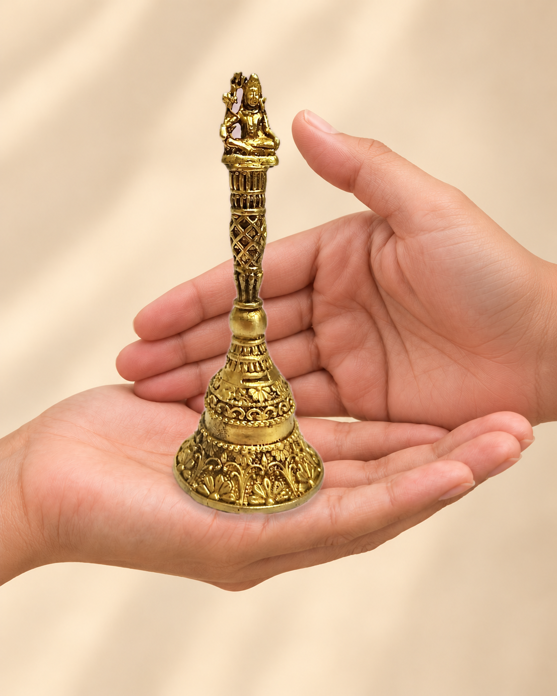 Illustrative scale view of Shiva Brass Pooja Bell – 5 Inch resting on an adult open palm; listed height 5 inches.